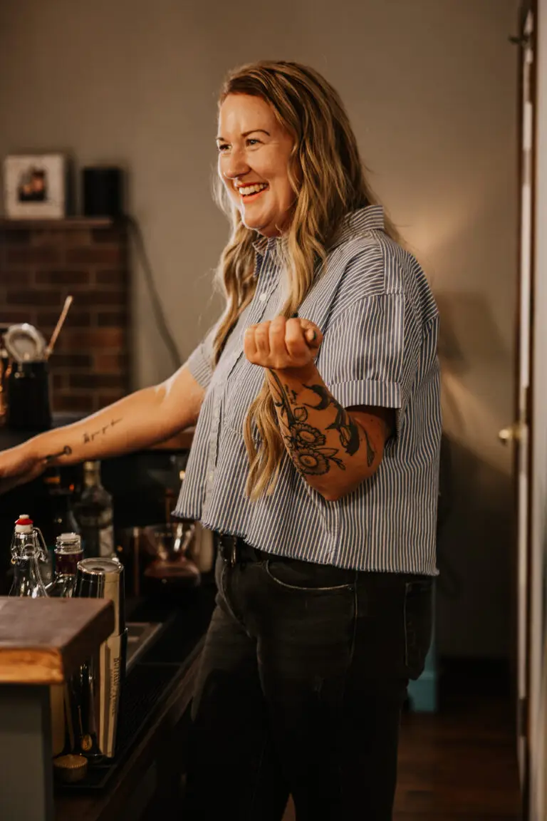 Becky of The Portable Pour laughing while mixing drinks behind the bar at a private party in Loveland, Colorado